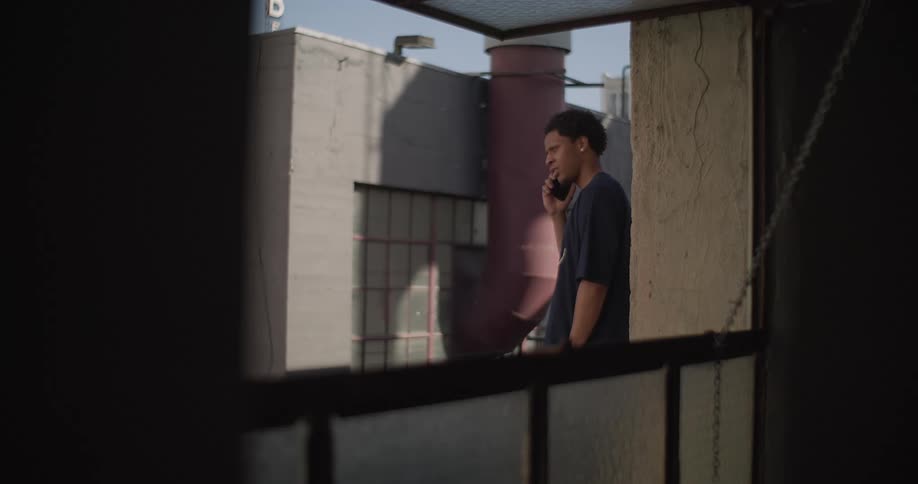 Man on balcony talking on cell phone