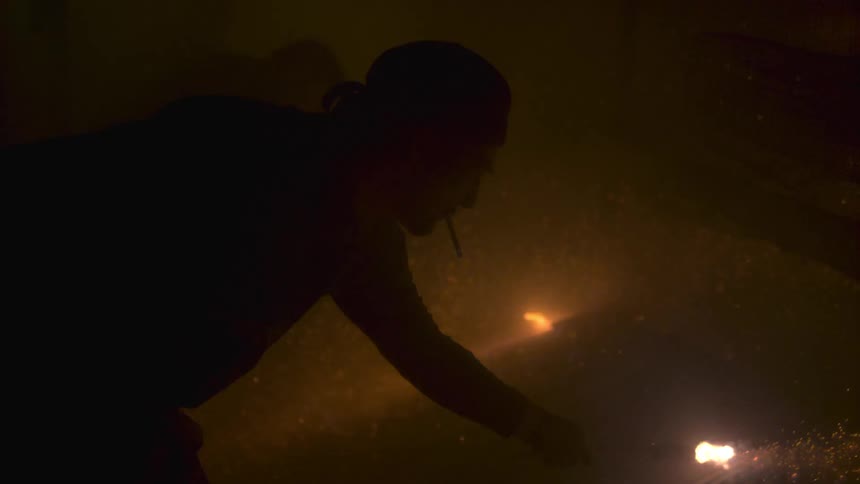Man holding a flaming bottle rocket
