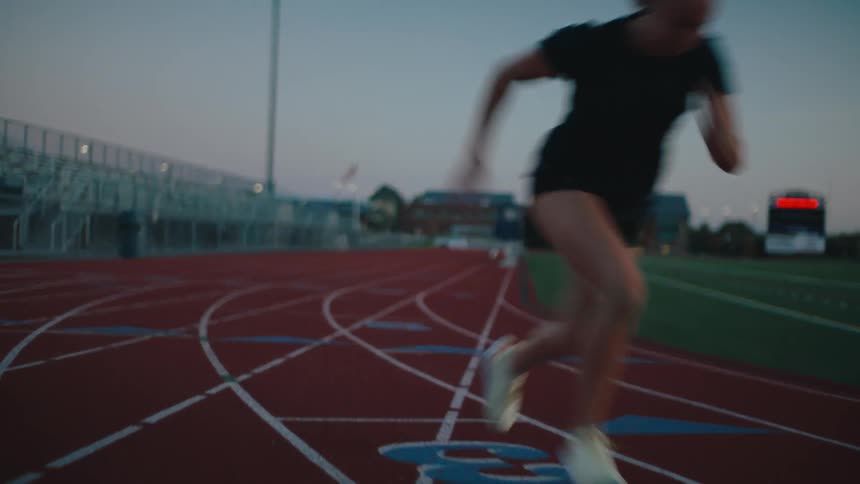 Woman running hard on an athletics track