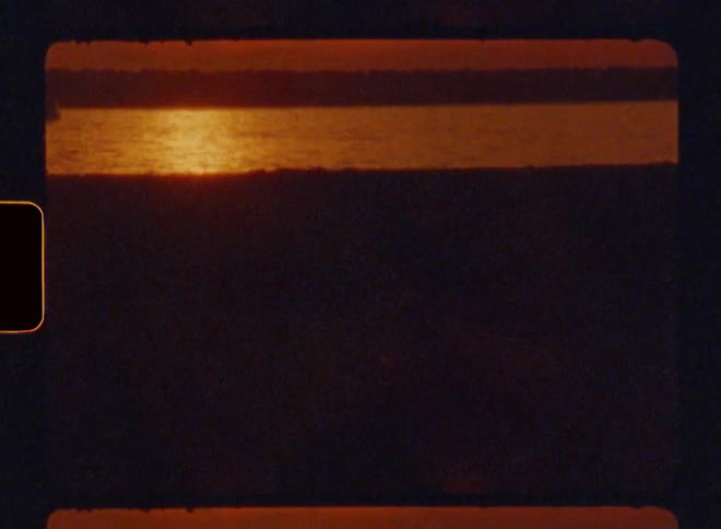 Lake by the shore with reddish sun reflection