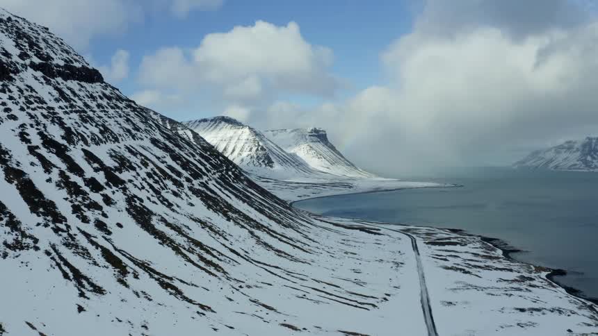 Aerial panorama of snowy mountains by the sea