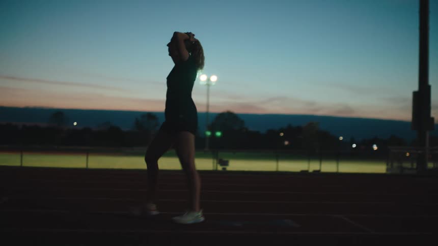 A woman walks on a racing track