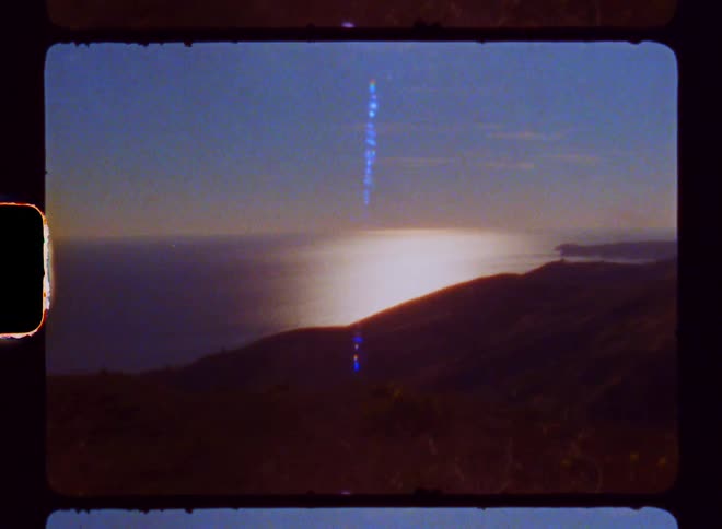 A mountainous coastal area with bright sunlight