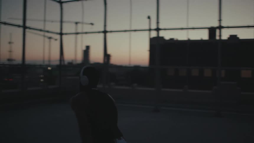 Man with headphones playing basketball and shooting ball on the court