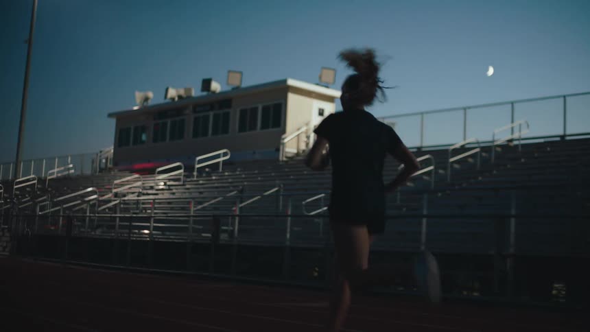 A young woman runs on a race track