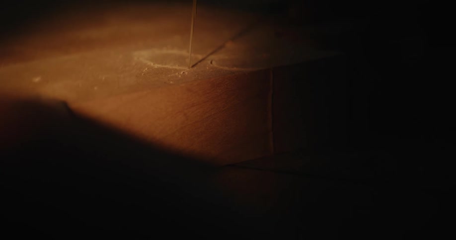 A blade slicing through a wooden board