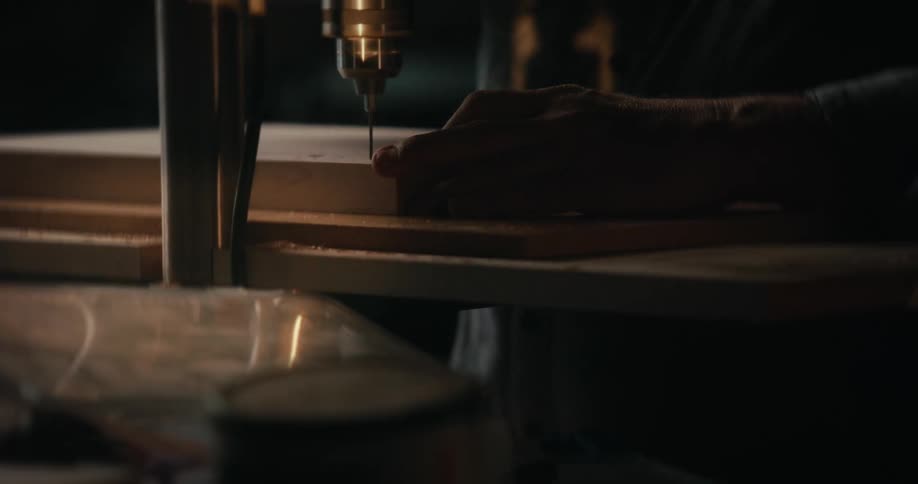 A man is drilling into wood