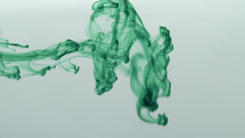 Slow motion of green liquid flowing in front of a white background