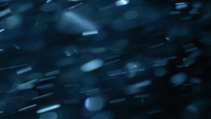 Particles reflect light while blowing by in the wind