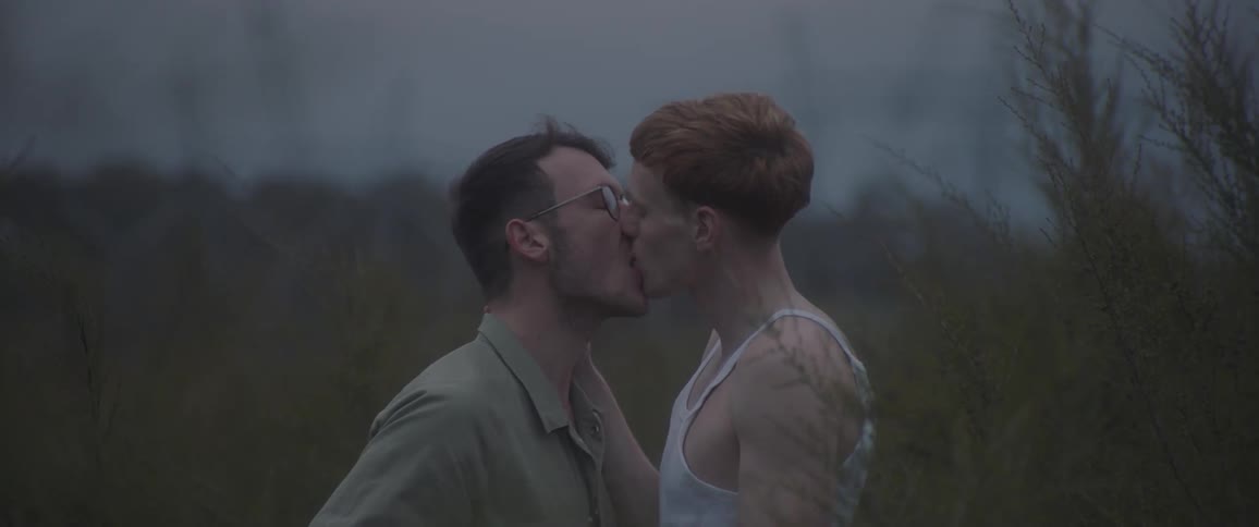 Two men kissing and smiling