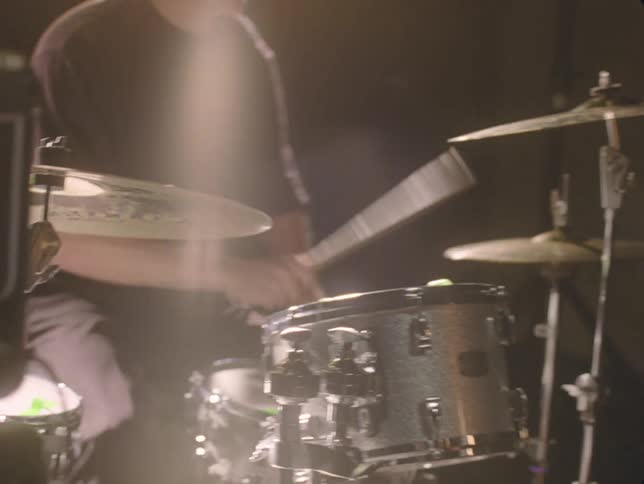 A man vigorously playing drums