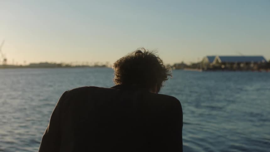 A man next to a large body of water gasping for air