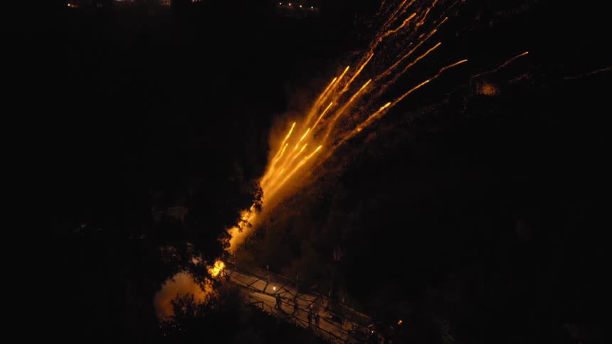 Tracer fire at night over a city