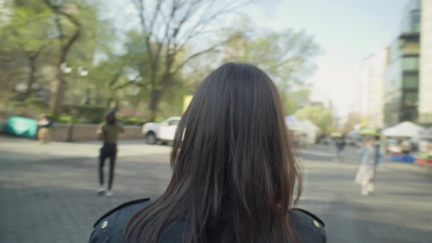 A woman walks to a park entrance