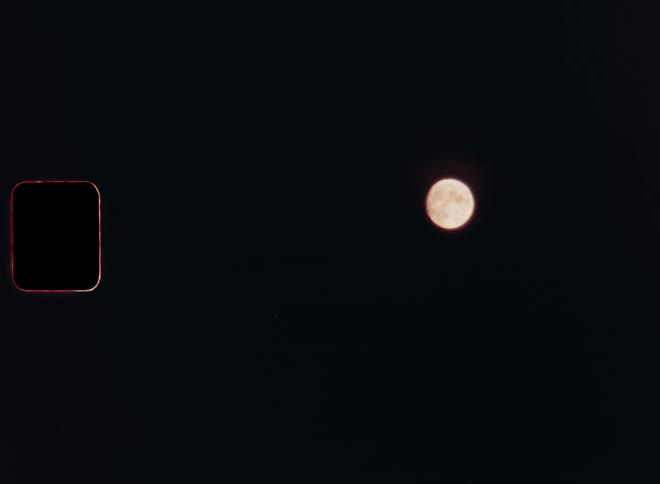 View of the night sky with a golden shining full moon in the middle of the night in the darkness of nighttime on vintage Super 8 film