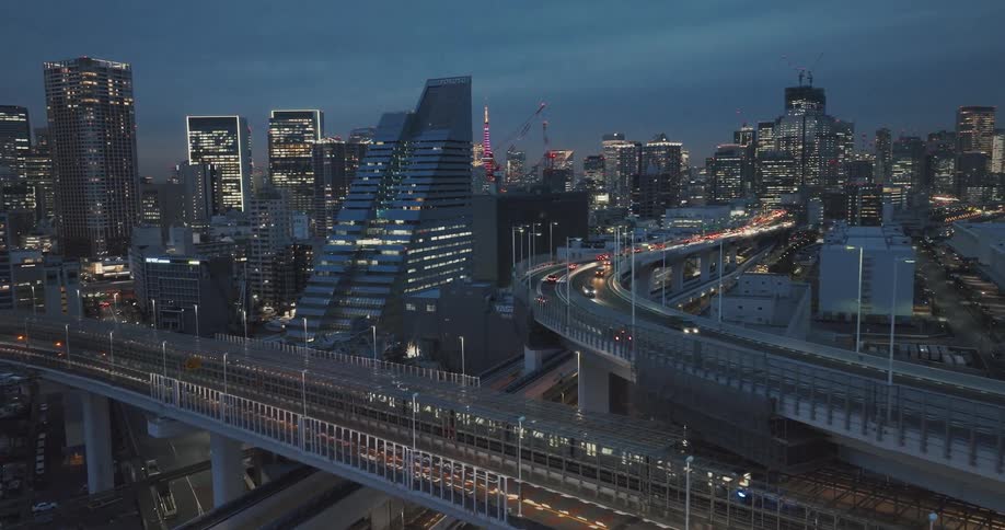 Aerial panorama of Tokyo overpasses with vehicle traffic and illuminated skyscrapers at night