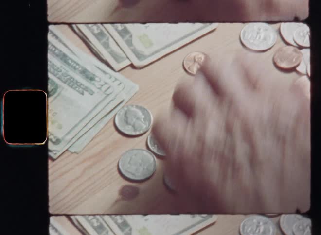 Closeup of a middle-aged male hand counting silver and bronze cent coins and US dollar bills on a wooden table in order to save money or doing the bookkeeping of his business while dealing with inflation and increasing living costs