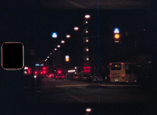 A bus takes a turn on a busy city street at night