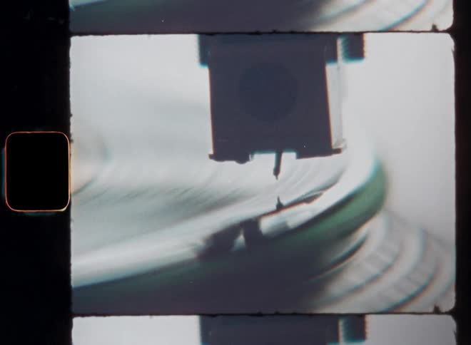 The sound needle of a turntable from the 1990s or the nineties slowly gets closer to a classic Hip-Hop vinyl record creating suspense and tension before the music starts playing as the EP or Album is spinning in motion with circular movement