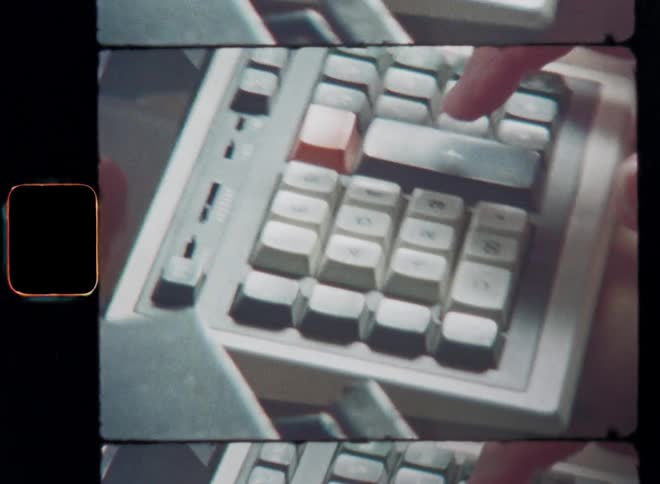 Dynamic handheld close up with shaky camera movement of a person doing math while rapidly and precisely pressing the keys of a calculator caught on vintage S8 mm film as symbol for old technology and technical progress