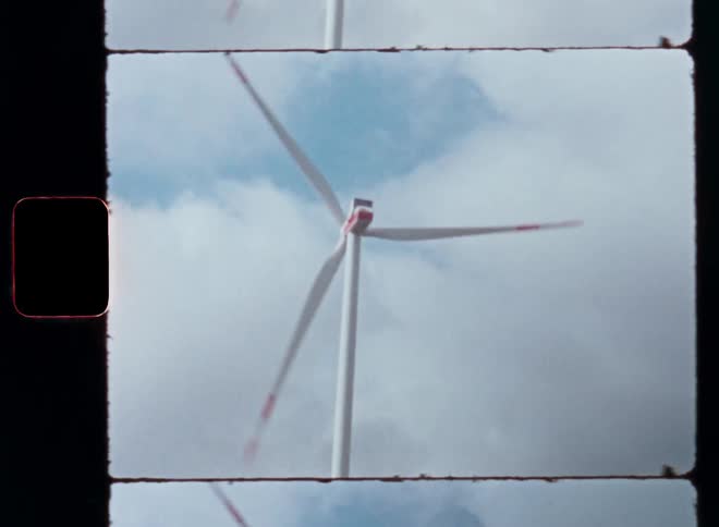 In a vast green field wind turbines spin gracefully harnessing the power of the wind to generate clean energy