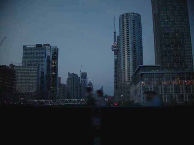 A tall tower stands amidst other skyscrapers in a metropolitan area
