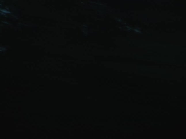 Buildings in a city and trees filmed in fast chaotic movements at dusk