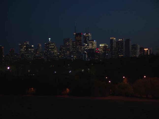 The landscape showcases an illuminated city skyline adorned with towering skyscrapers