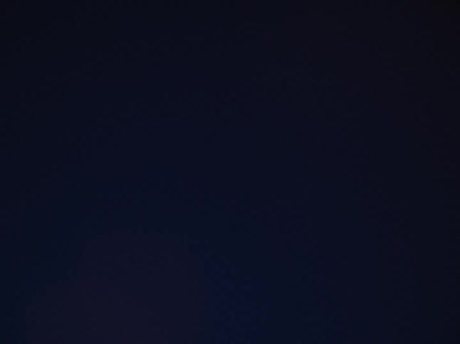 A lamp post hangs in the night sky