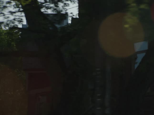 A house and trees are illuminated by sunlight in the morning