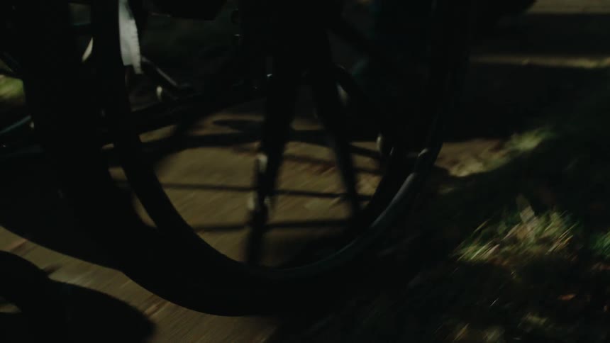 A person pushes a wheelchair on the sidewalk