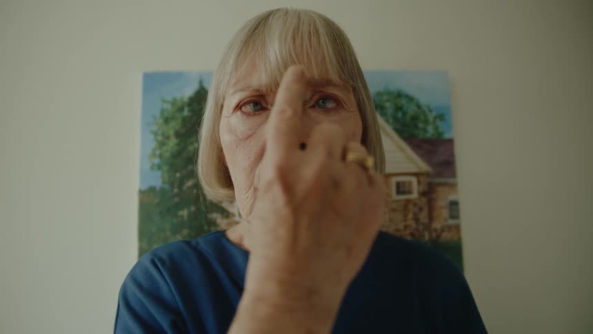 Older woman crosses her eyes while she tracks her finger moving toward her face
