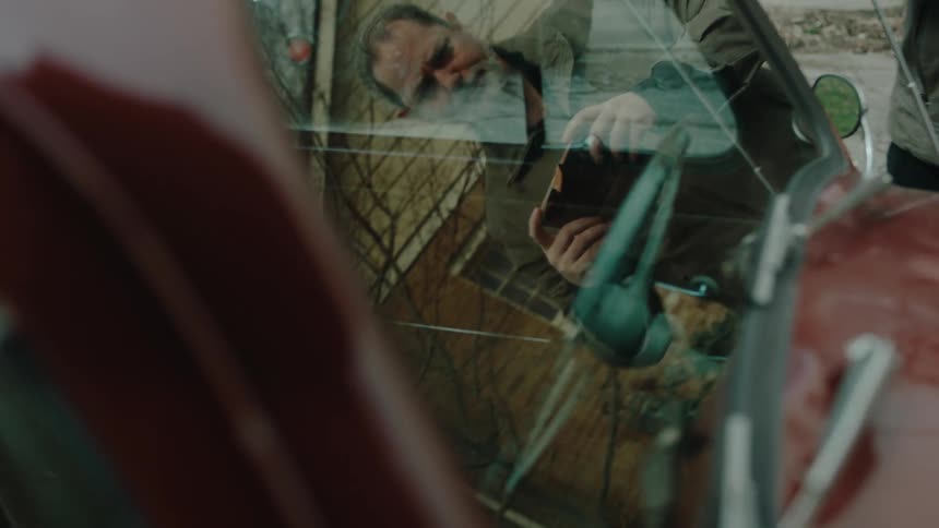 A man photographs the car with his cell phone