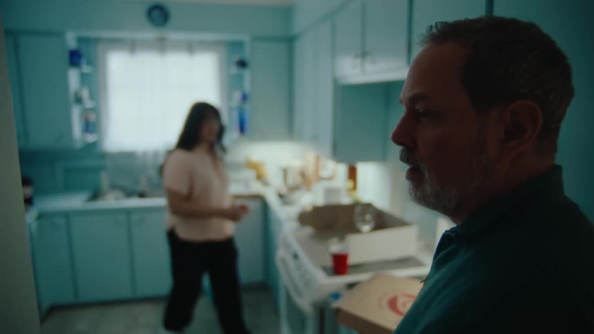 Woman in the kitchen and a man next to her who runs into the hallway