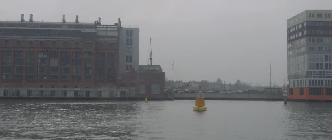 Buildings of a city by the sea on a foggy day