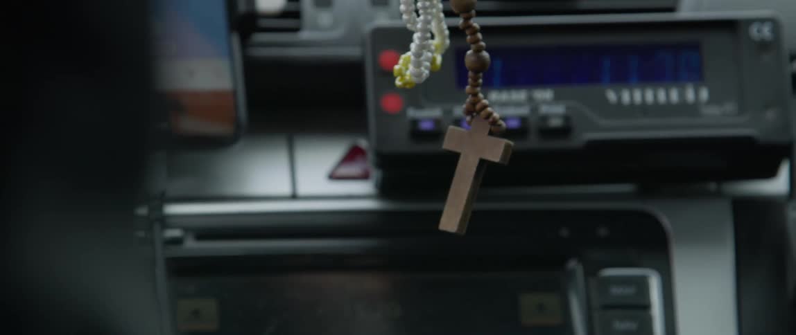 Wooden rosary hanging from a car