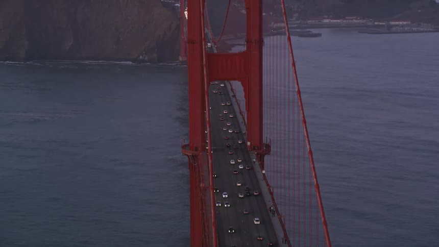 Commuters driving across the golden gate bridge at dusk
