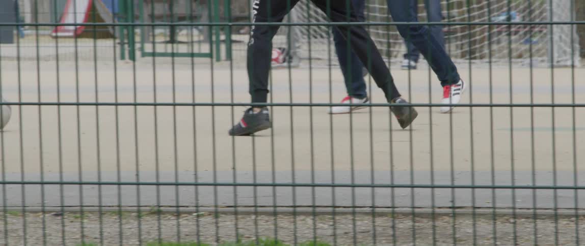 Legs of boys playing soccer on a court
