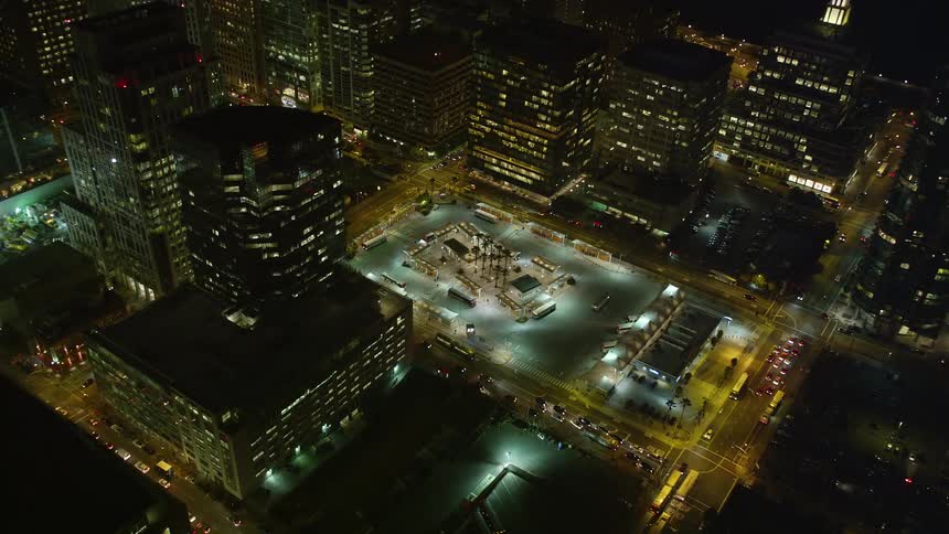 Traffic moves through a busy city at night