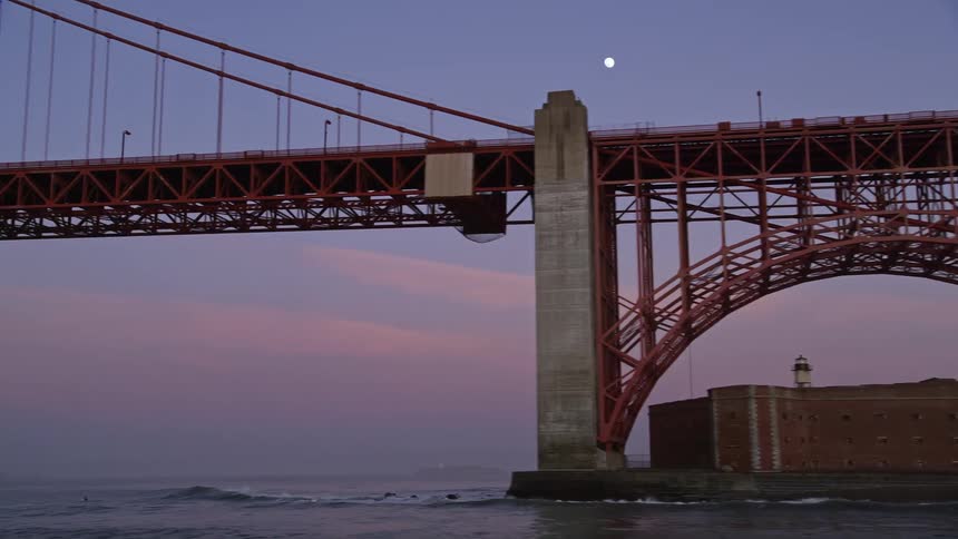Panorama of the golden gate bridge in a sea at the coast and a purple sky with the moon