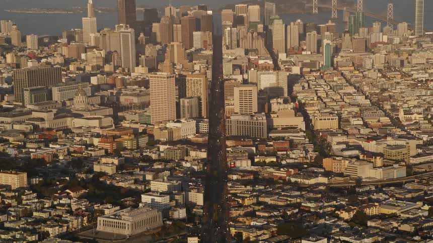 An aerial view of san francisco densely packed with buildingsand a body of water visible in the background