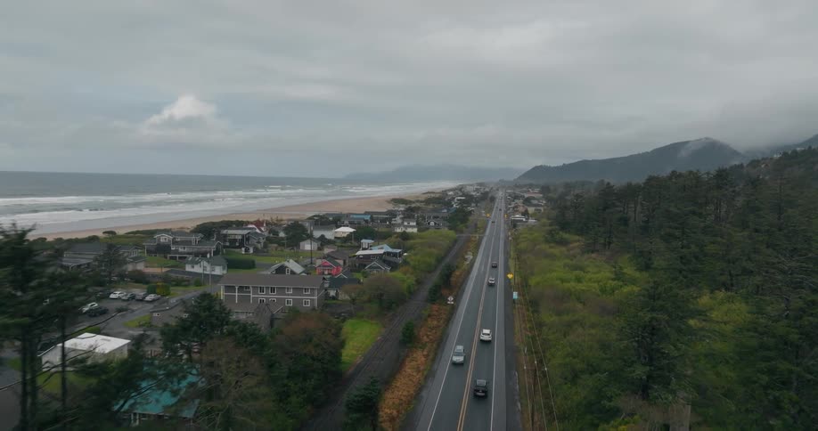 Cars drive past the homes on the shore
