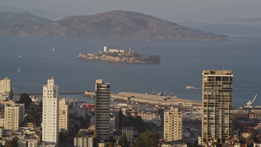 Aerial panorama of large buildings in a seaside metropolis and a body like a cargo ship and the sea coast in the background
