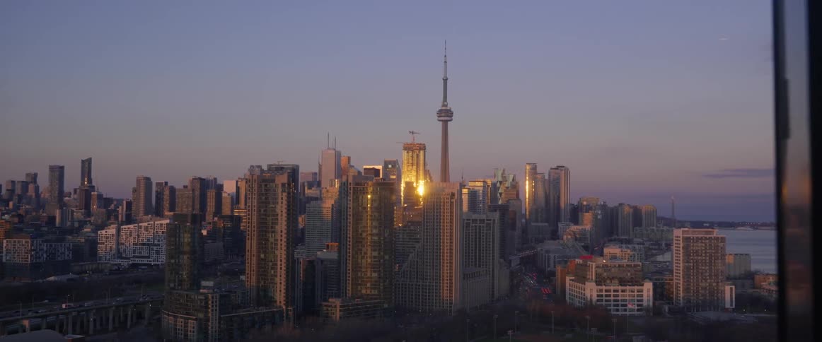 Skyline of toronto at sunset seen from an apartment window