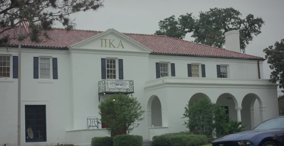 A car is parked outside a fraternity house