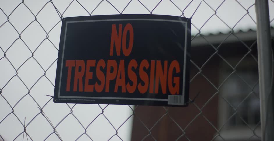 A no trespassing sign is on the fence