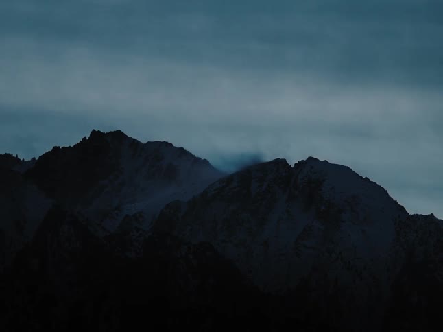 Mist floats around the top of a mountain range