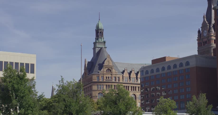 The milwaukee city hall surrounded by modern buildings under a blue sky