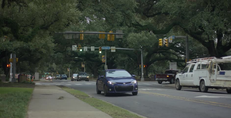 Traffic drives through a suburban intersection