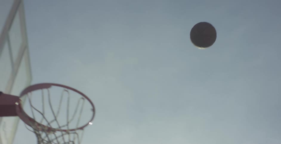 A basketball flies through the air and drops through the net